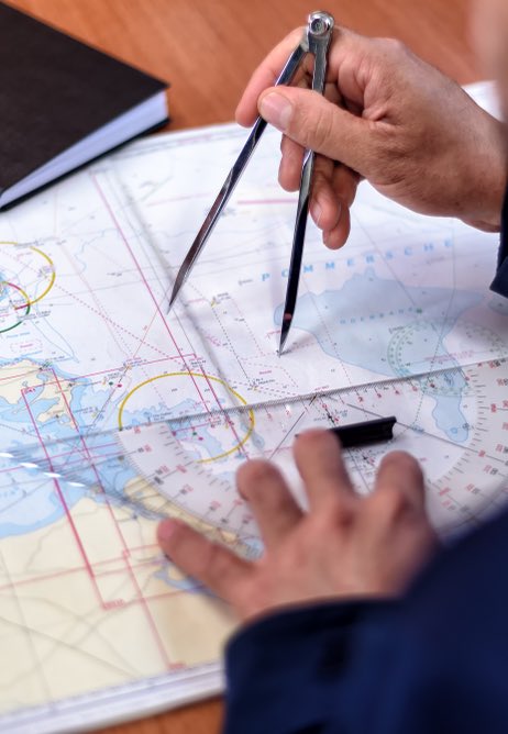 navigation with sea charts in the chart room on a sailing yacht