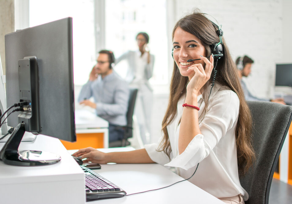 Young,Friendly,Operator,Woman,Agent,With,Headsets,Working,In,A
