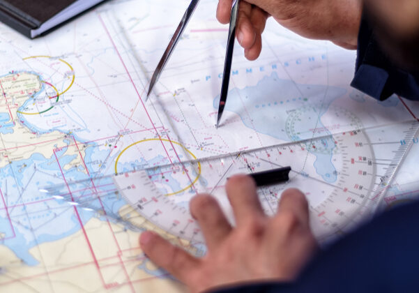 navigation with sea charts in the chart room on a sailing yacht